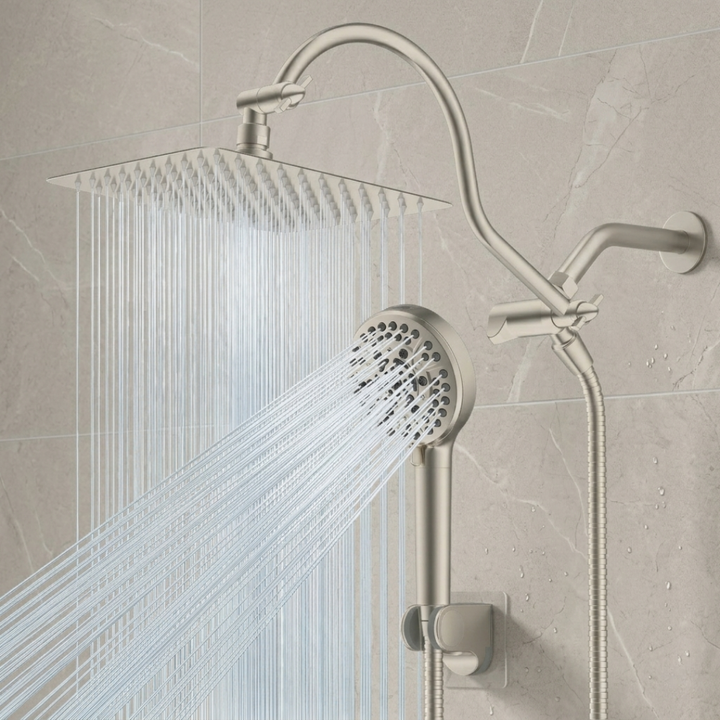 Brushed Bickle shower head with water flowing against a tiled wall